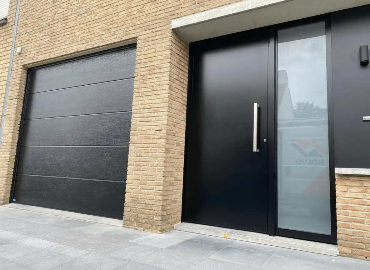 Dezelfde garagepoort en buitendeur na herlakken in donkergrijs Dezelfde garagepoort en buitendeur na herlakken in donkergrijs